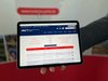 Ein Tablet wird ins Bild gehalten. Darauf ist die Website der Kreisvolkshochschule zu sehen.