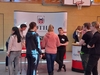 Zu sehen ist eine Gruppe Jugendliche, die an einem Messestand stehen. Sie unterhalten sich mit einer Mitarbeiterin. Im Hintergrund sieht man auf einer weißen Messewand das Logo vom Landkreis Gotha. 