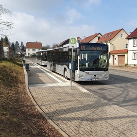 Zu sehen sind zwei Busse an einer Bushaltestelle