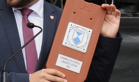 Zu sehen ist einen Schild, mit dem ein denkmalgeschütztes Gebäude versehen wird.