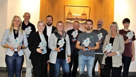 Zu sehen sind Vertreterinnen der Gewinnerteams gemeinsam mit Landrat Onno Eckert