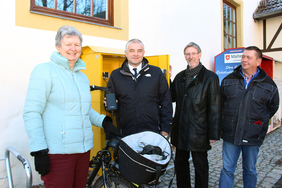 Christel Friedrich nutzte mit Unterstützung von Drei-Gleichen-Bürgermeister Jens Leffler, Landrat Konrad Gießmann und Ortsteilbürgermeister Karsten Ullrich (v.l.) die Neuerung, um die Akkus ihres Rades aufzufüllen.
