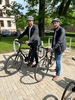 Im Foto sind Landrat Onno Eckert und Klimaschutzmanager Jan Heinichen zu sehen. Beide haben einen Helm auf dem Kopf und je ein Fahrrad dabei. Sie sind draußen auf dem Gelände des Landratsamtes.